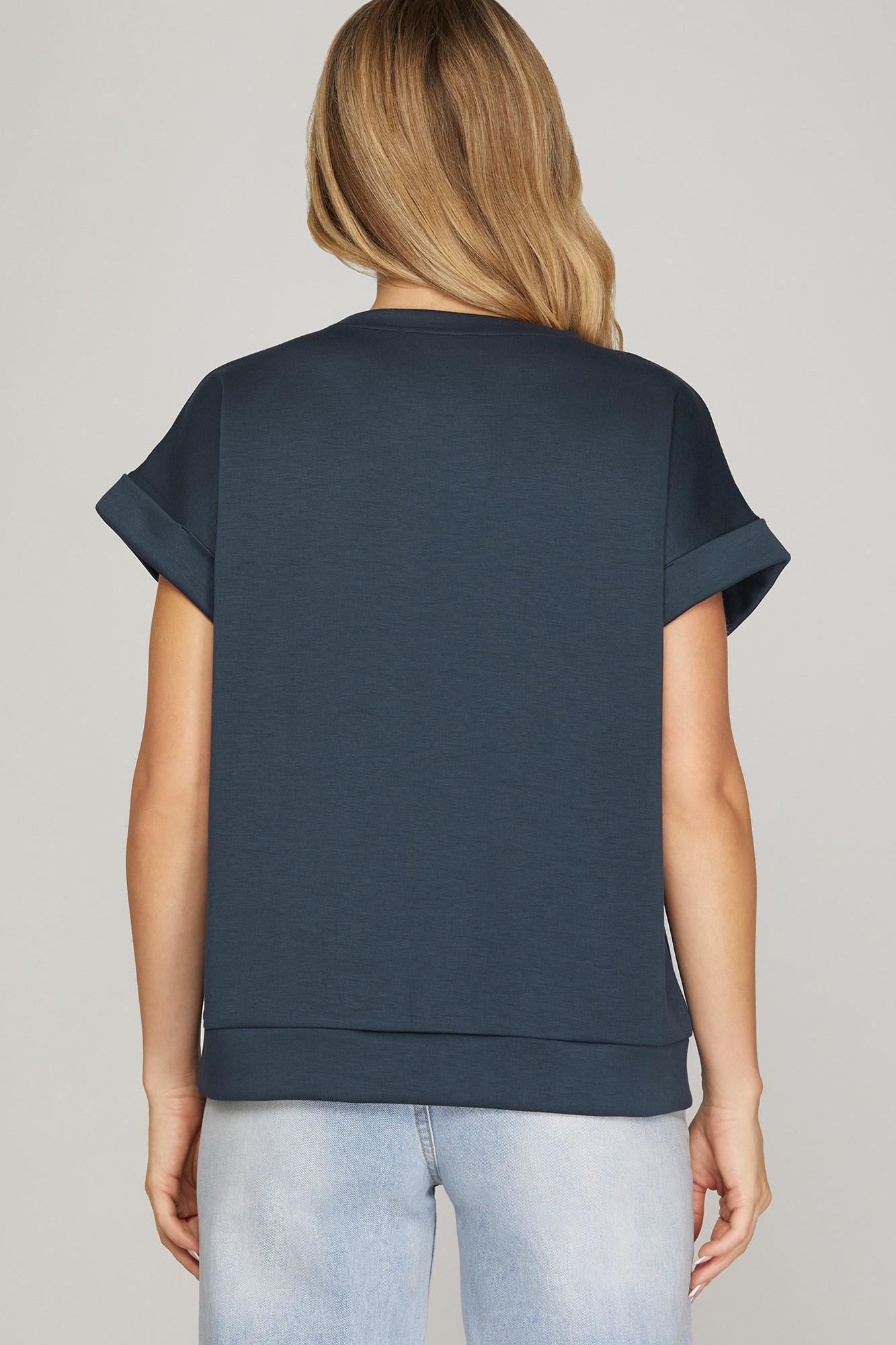 Person wearing a navy blue top and light blue jeans on a gray background