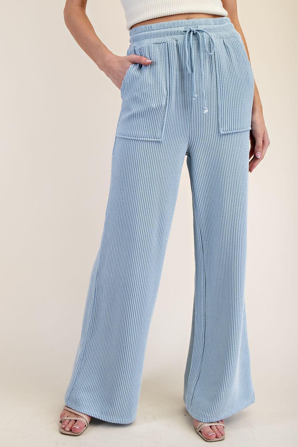 Light blue striped pants worn by a person on a beige background