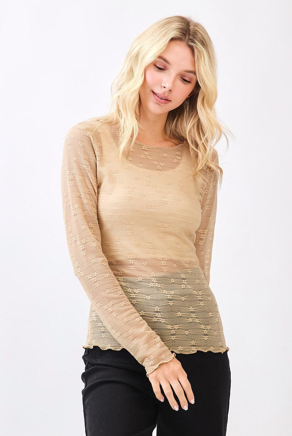 Woman wearing a beige long-sleeve top on a white background