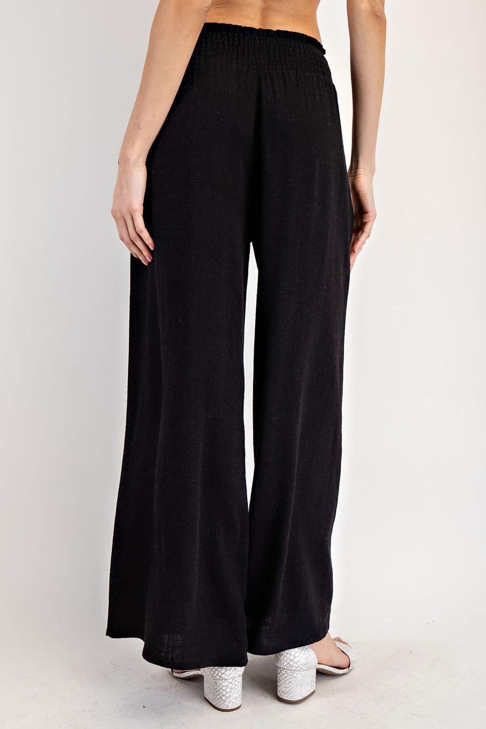 Black wide-leg pants worn by a person on a white background