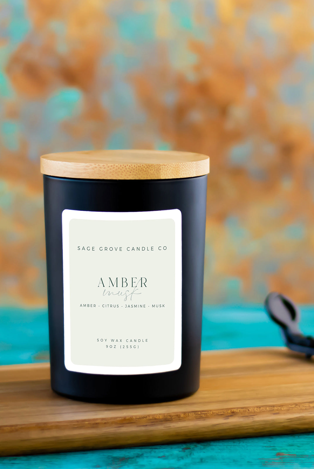 amber musk candle in ceramic jar on wood surface