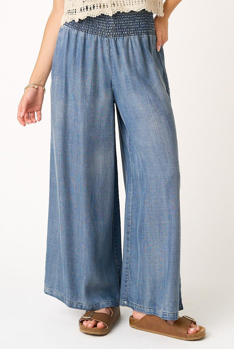 Denim wide-leg pants worn by a person on a white background