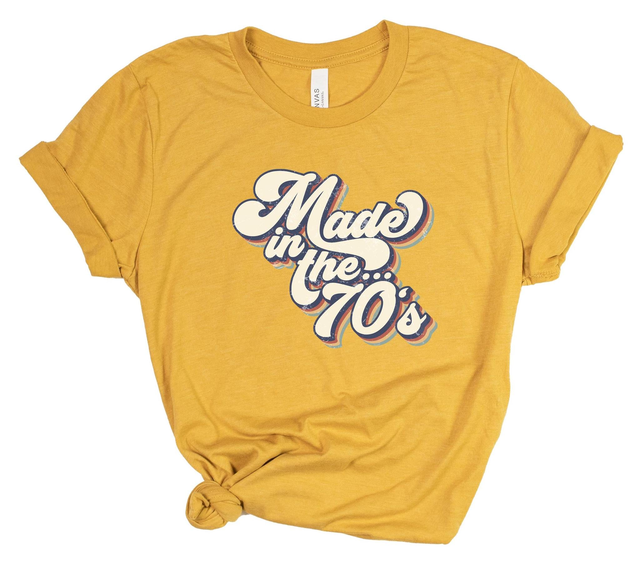 Yellow t-shirt with 'Made in the 70's' text on a white background