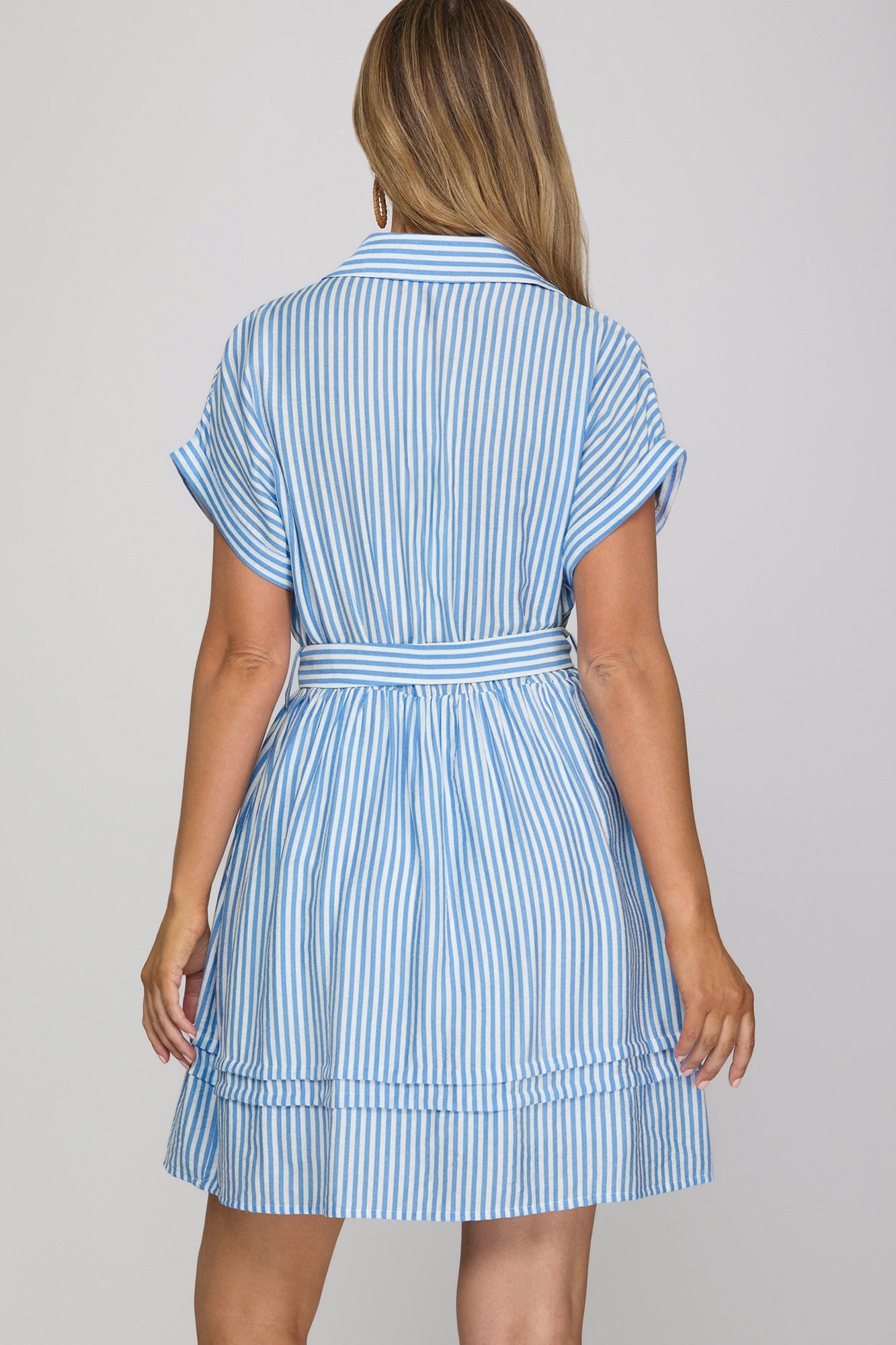 Woman wearing a blue and white striped dress on a gray background