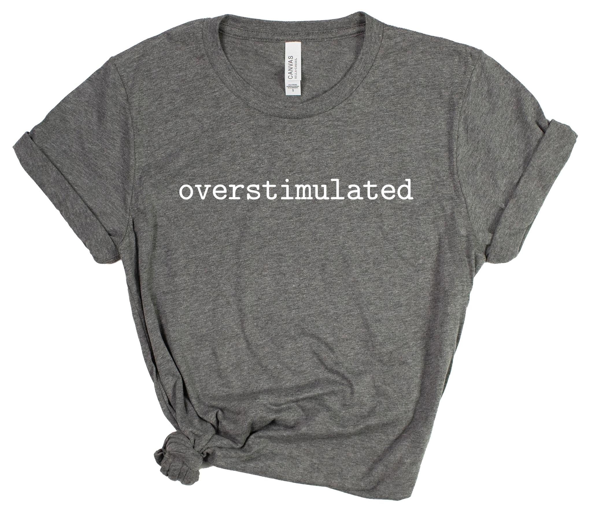 Gray t-shirt with 'overstimulated' text on a white background