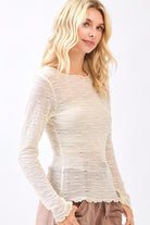 Woman wearing a white long-sleeve top with lace details on a white background