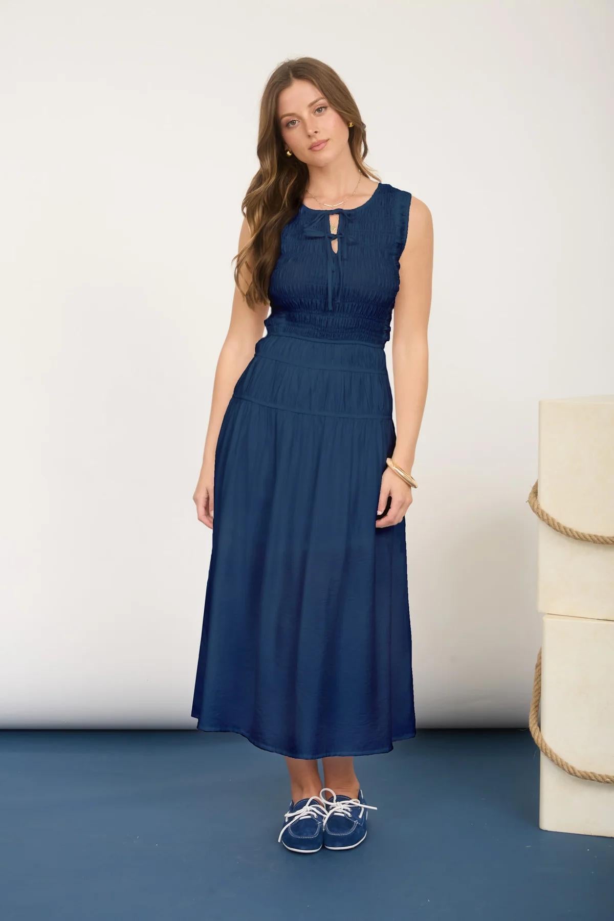 Woman wearing a blue dress standing against a white background