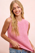 Woman wearing a pink sleeveless knitted top against a light pink background