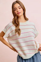 Woman wearing a striped sweater against a pink background