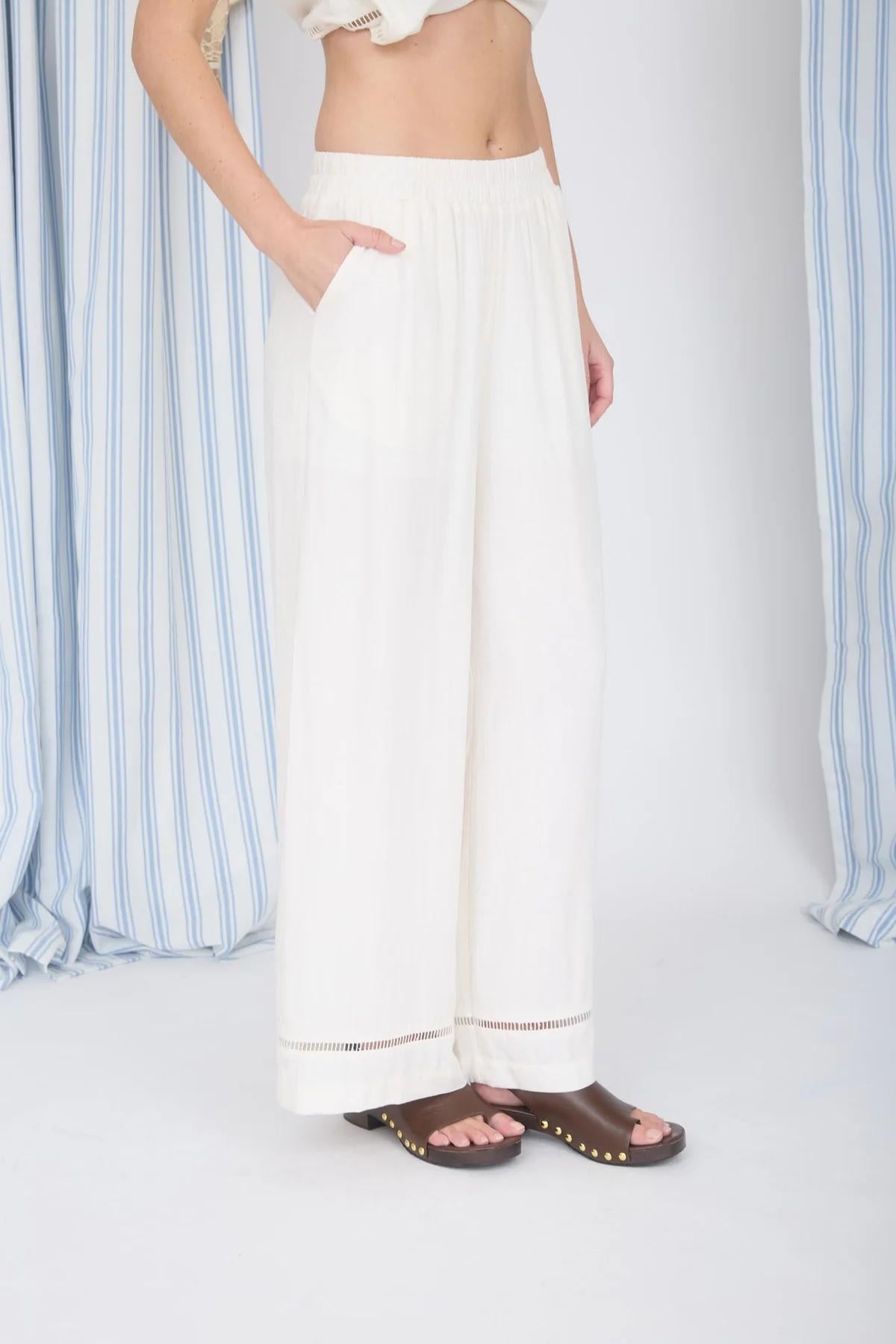 White wide-leg pants worn by a person on a white background