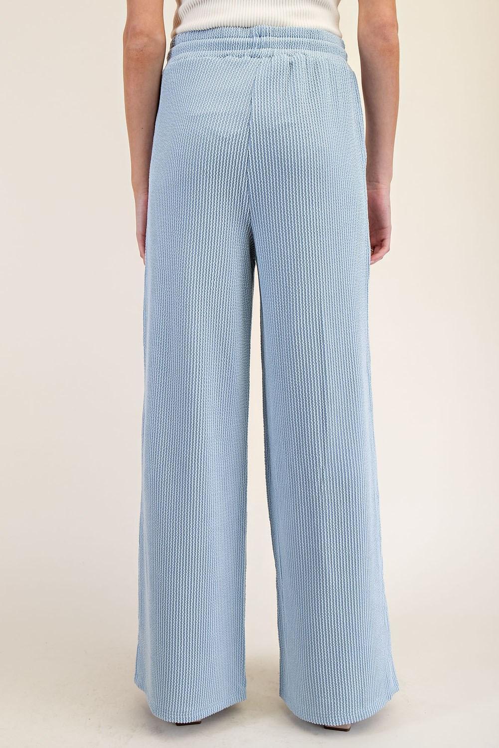 Light blue striped pants worn by a person on a beige background