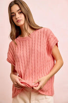 Woman wearing a pink knitted top against a pink background