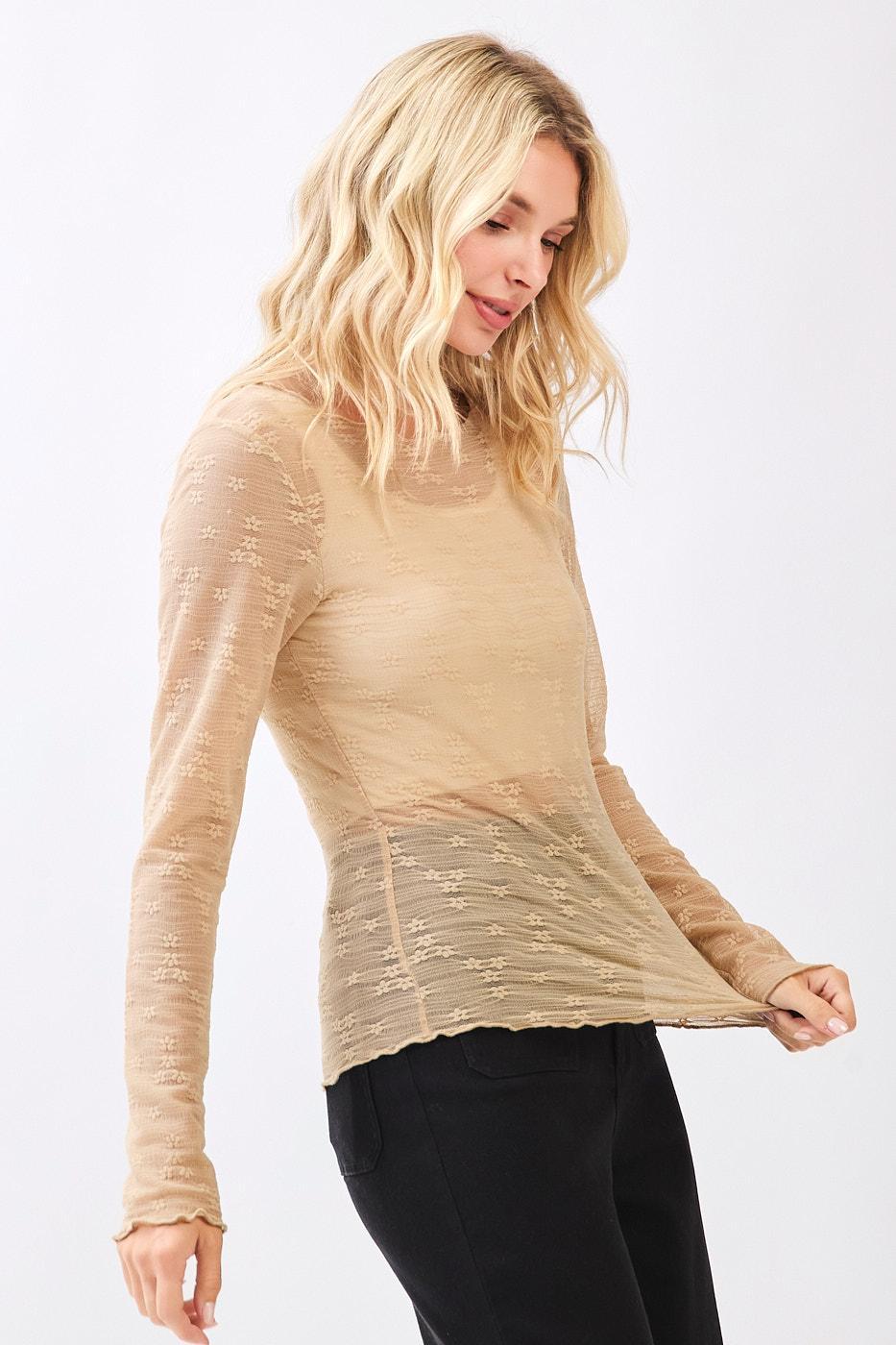 Woman wearing a beige long-sleeve top on a white background