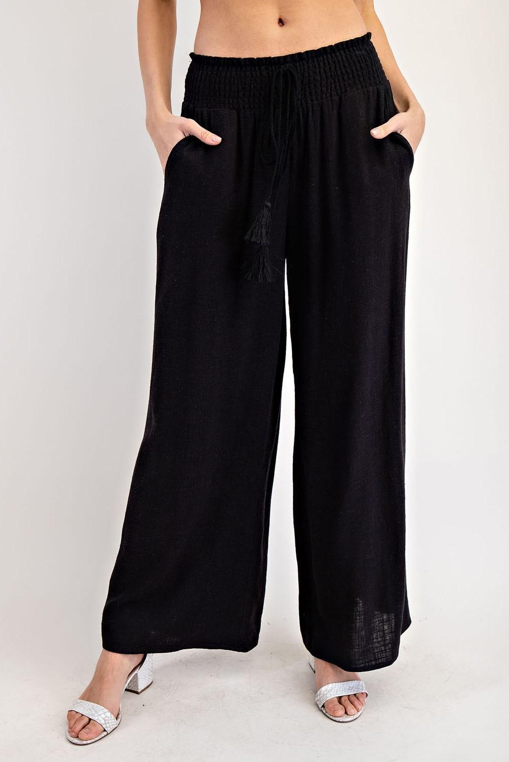 Black wide-leg pants worn by a person on a white background