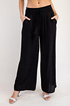 Black wide-leg pants worn by a person on a white background