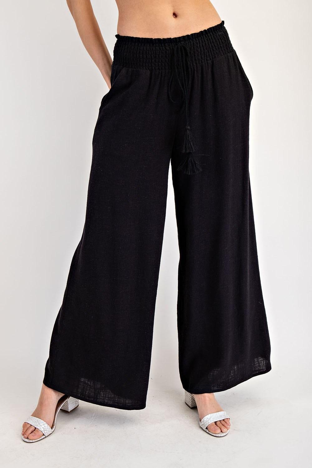 Black wide-leg pants worn by a person on a white background