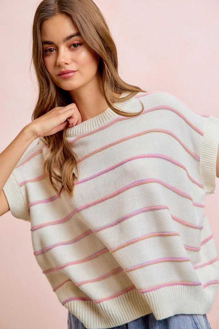 Woman wearing a striped sweater against a pink background
