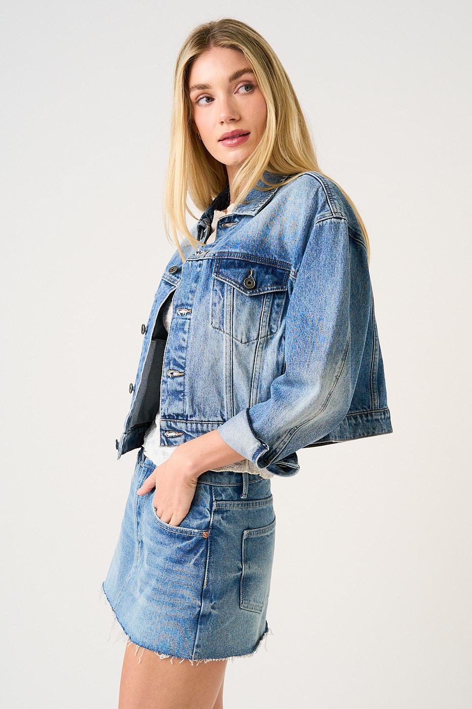 Woman wearing a denim jacket and skirt on a white background