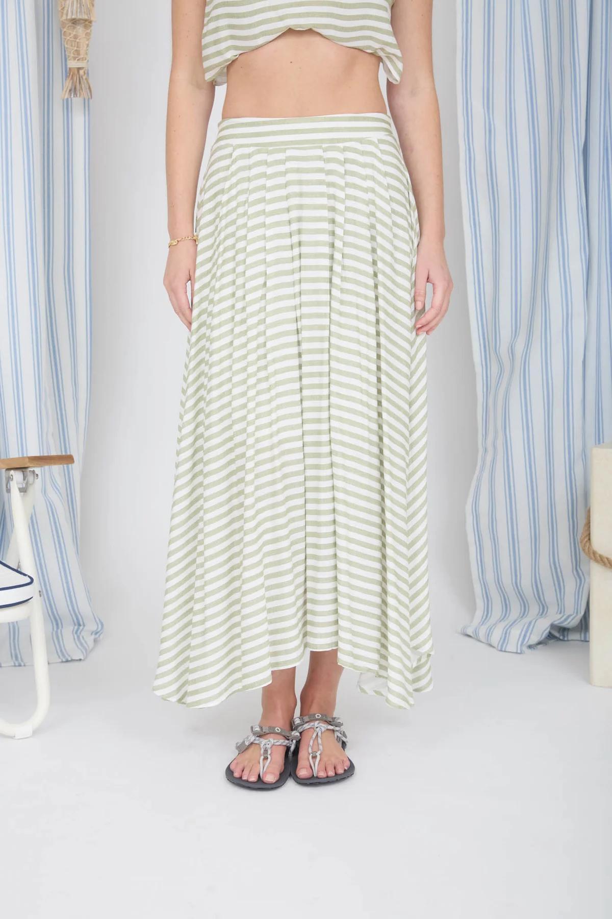 Person wearing a striped skirt and top in a room with striped curtains.