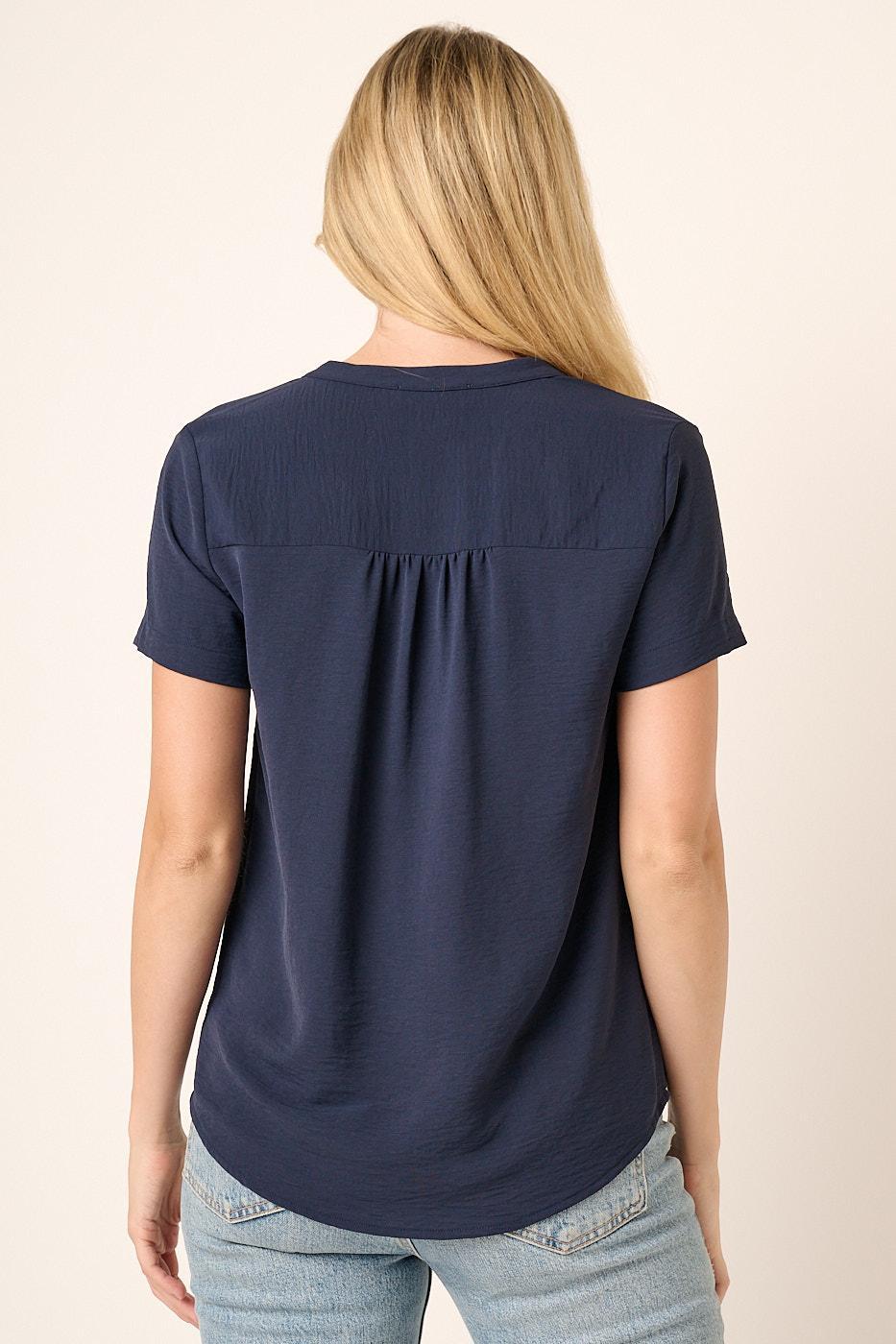 Person wearing a navy blue t-shirt with a plain background