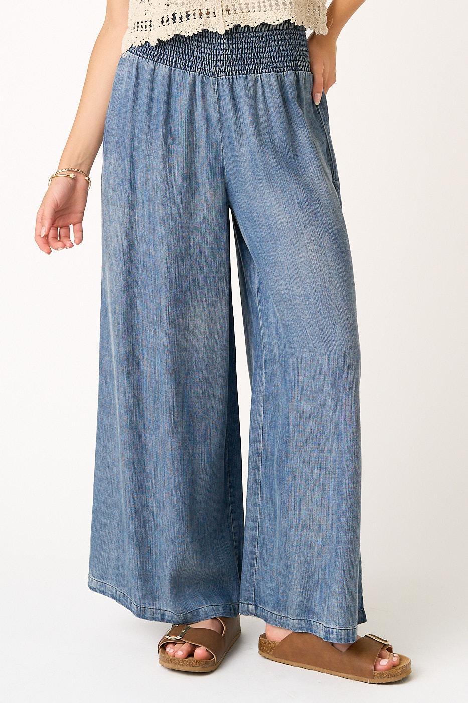 Denim wide-leg pants worn by a person on a white background