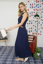 Woman in a navy blue dress standing in a room with a colorful star-patterned wall.