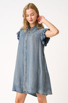 Woman wearing a denim dress with ruffled sleeves on a white background