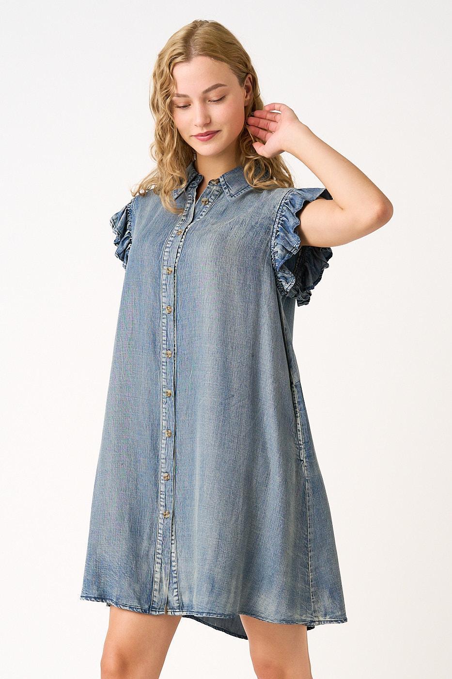 Woman wearing a denim dress with ruffled sleeves on a white background