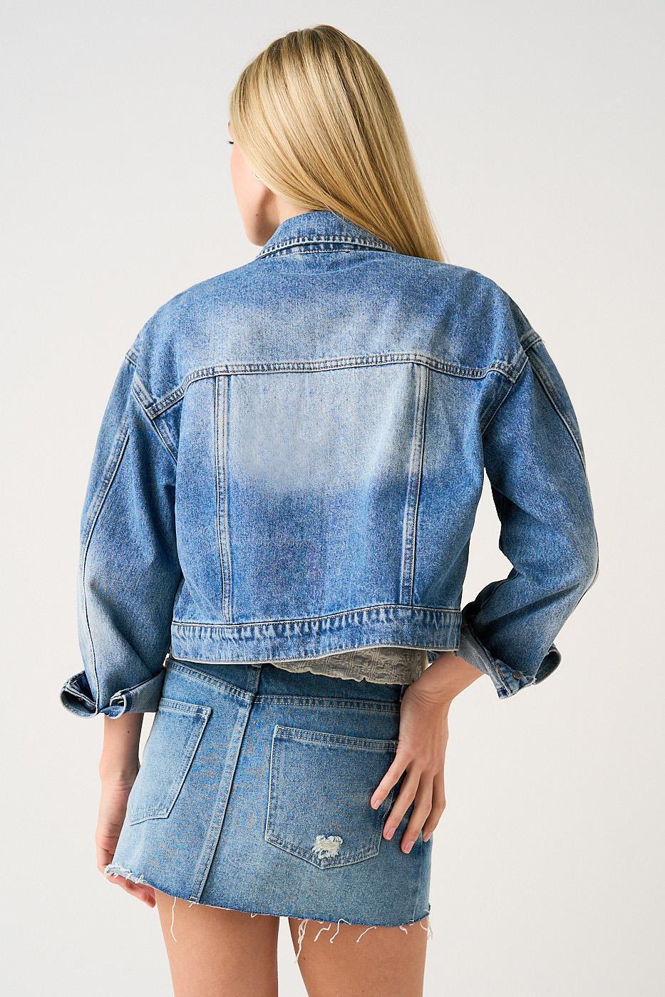 Person wearing a blue denim jacket and skirt on a white background