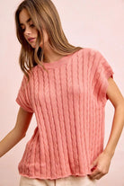 Woman wearing a pink knitted top against a pink background