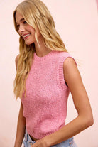 Woman wearing a pink sleeveless knitted top against a pink background