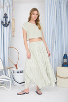 Woman in a striped outfit standing in a room with decorative items.